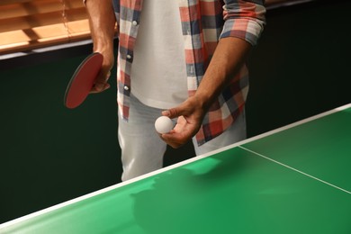 Man playing ping pong indoors, closeup view
