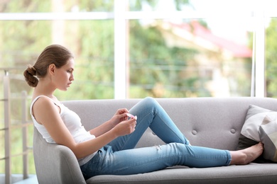 Young woman with pregnancy test at home. Gynecology