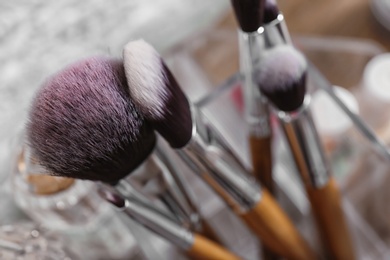 Organizer with brushes for makeup on table, closeup