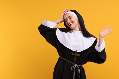 Photo of Happy woman in nun habit against orange background. Space for text
