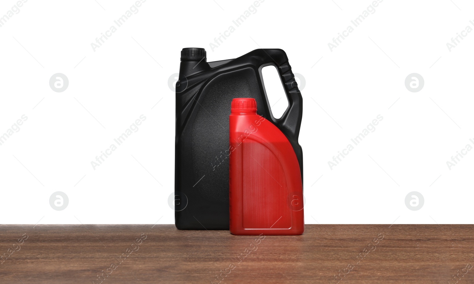 Photo of Motor oil in different containers on wooden table against white background