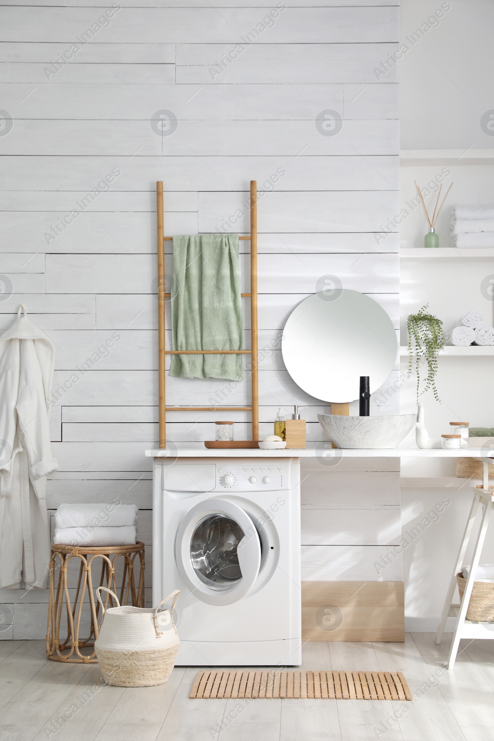 Photo of Stylish bathroom interior with modern washing machine