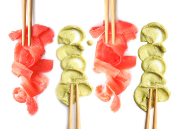 Set of delicious sauce condiments and chopsticks on white background, top view