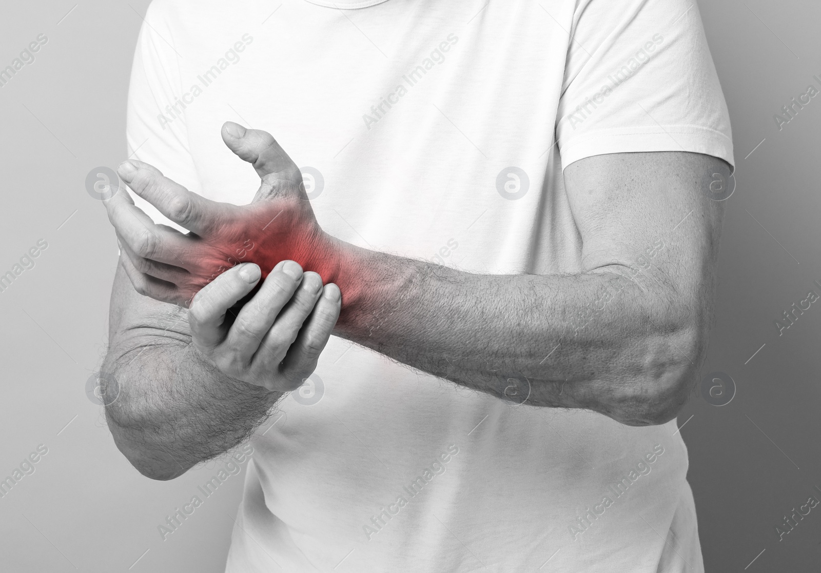 Image of Man suffering from pain in wrist, closeup. Black and white effect