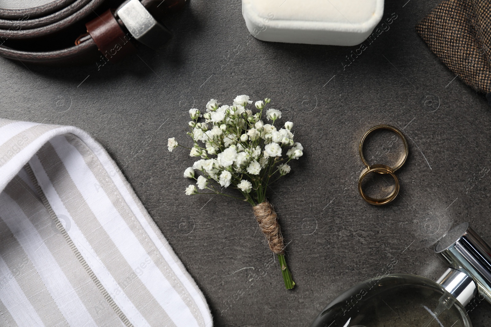 Photo of Wedding stuff. Flat lay composition with stylish boutonniere on black table