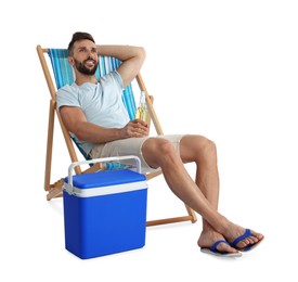 Happy man with bottle of beer resting in deck chair near cool box on white background