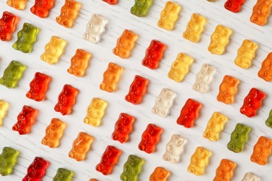 Flat lay composition with delicious color jelly bears on wooden table