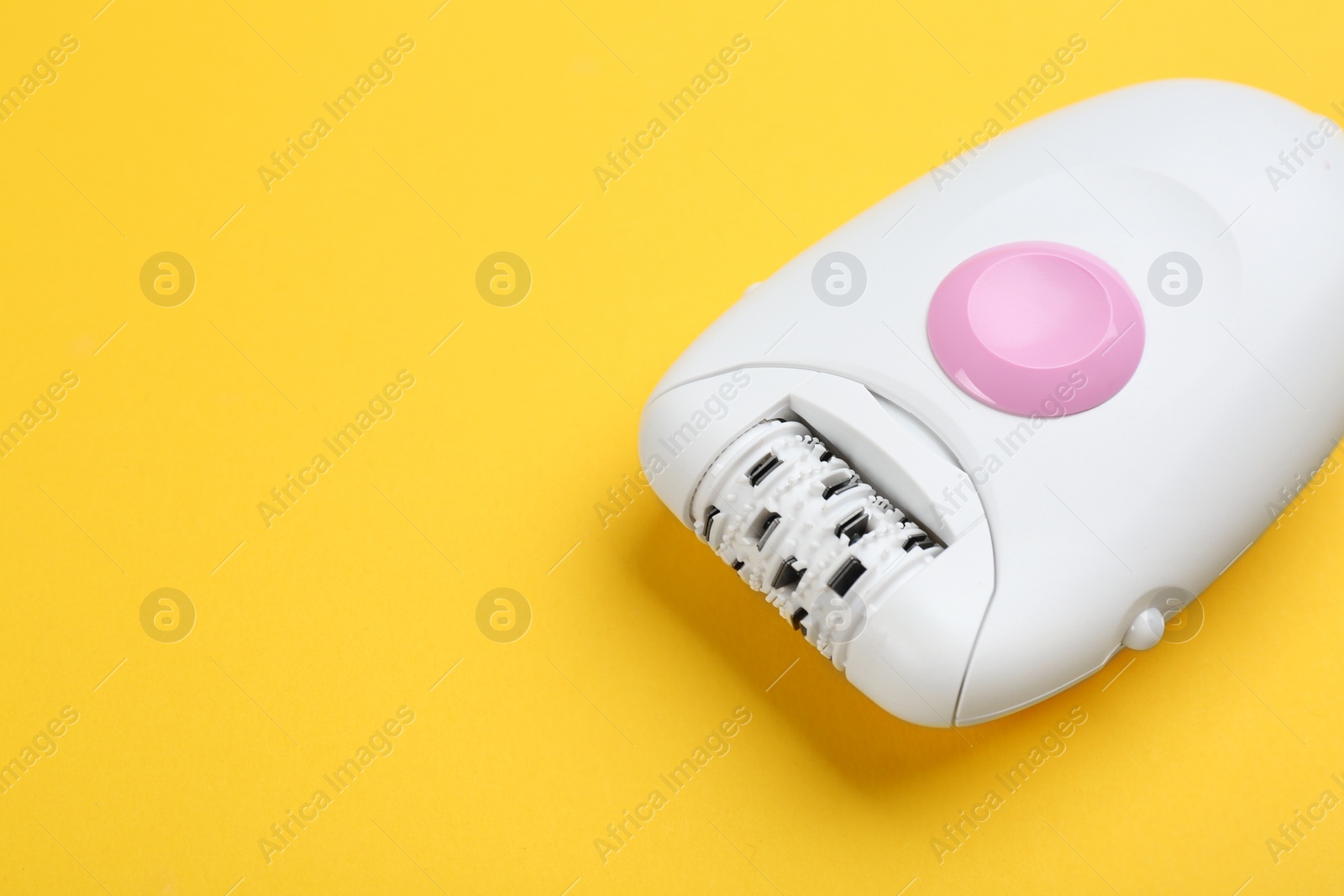 Image of Modern epilator on yellow background. Space for text