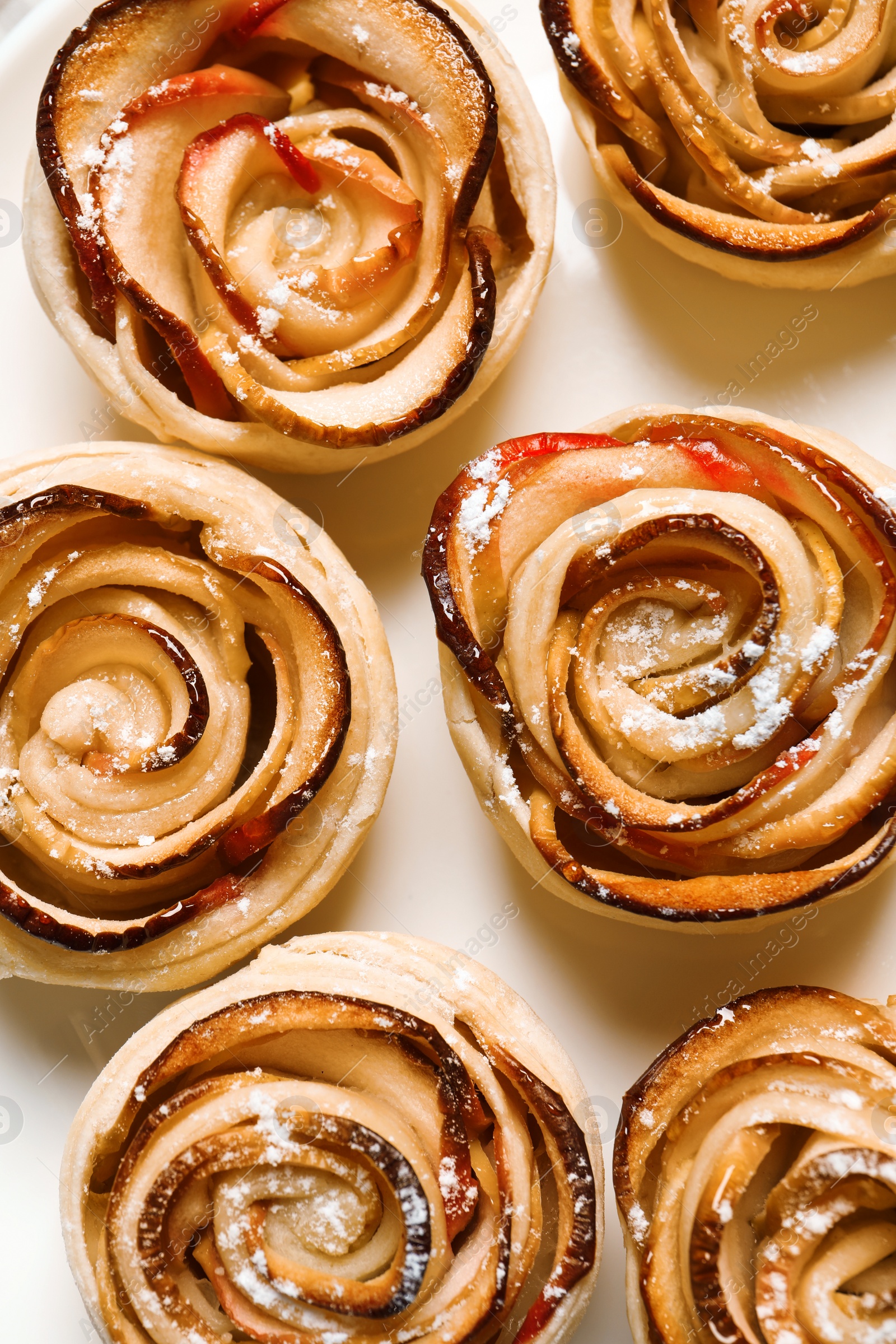 Photo of Freshly baked apple roses on light background, flat lay. Beautiful dessert