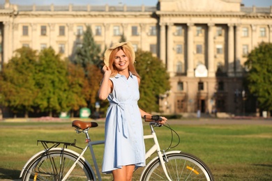 Photo of Happy woman with bicycle outdoors on summer day