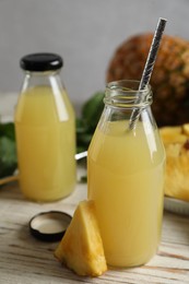 Photo of Delicious pineapple juice and fresh fruit on white table