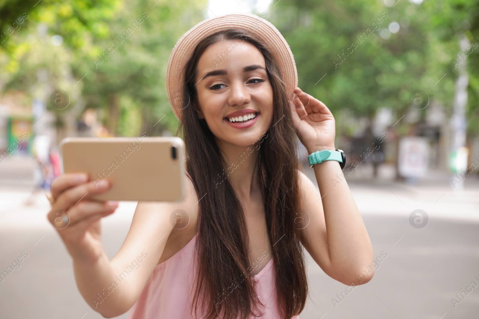 Photo of Beautiful young woman taking selfie outdoors on sunny day