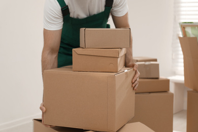 Man with cardboard boxes in room, closeup. Moving service