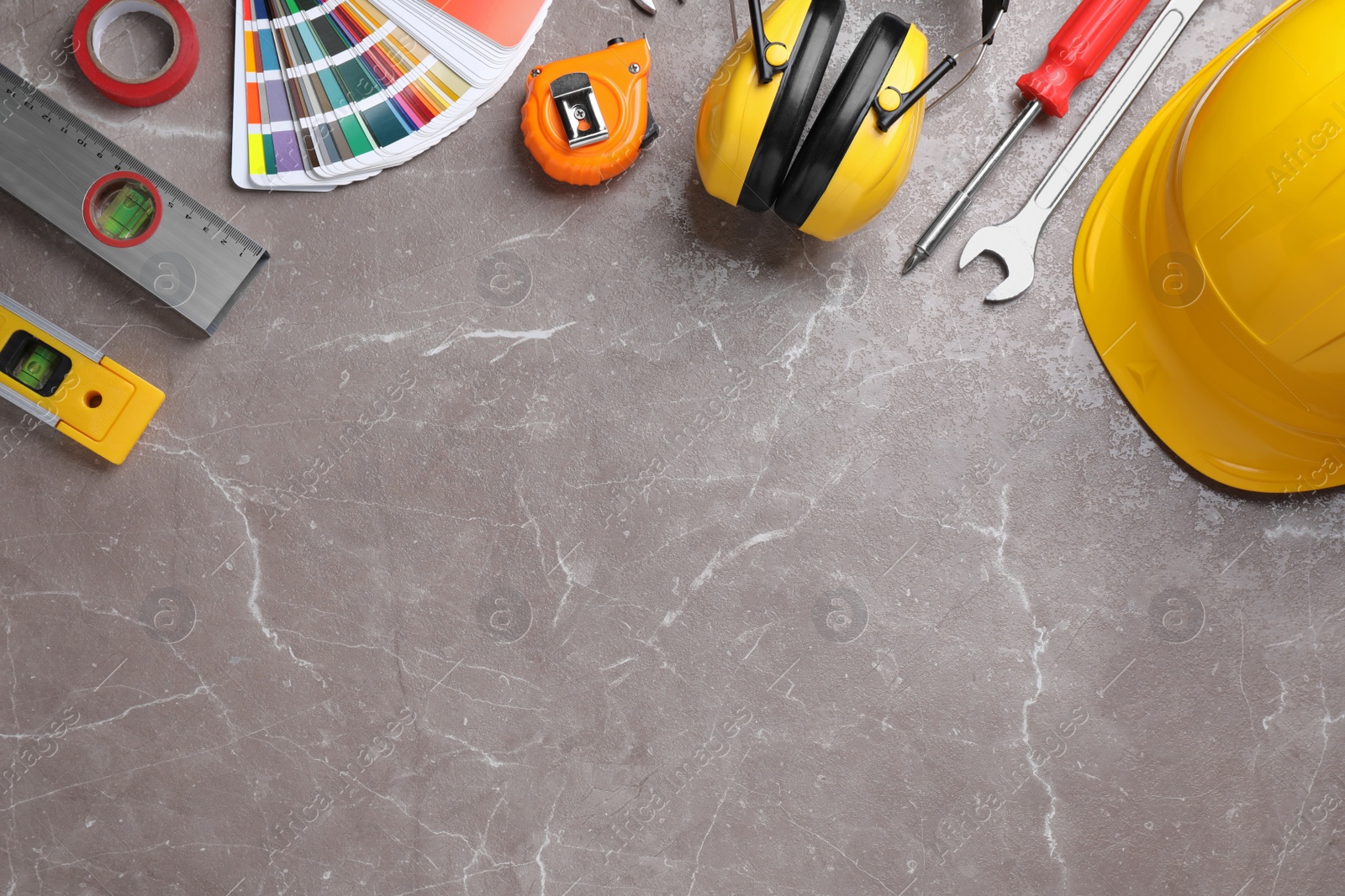 Photo of Flat lay composition with different construction tools on grey marble background. Space for text