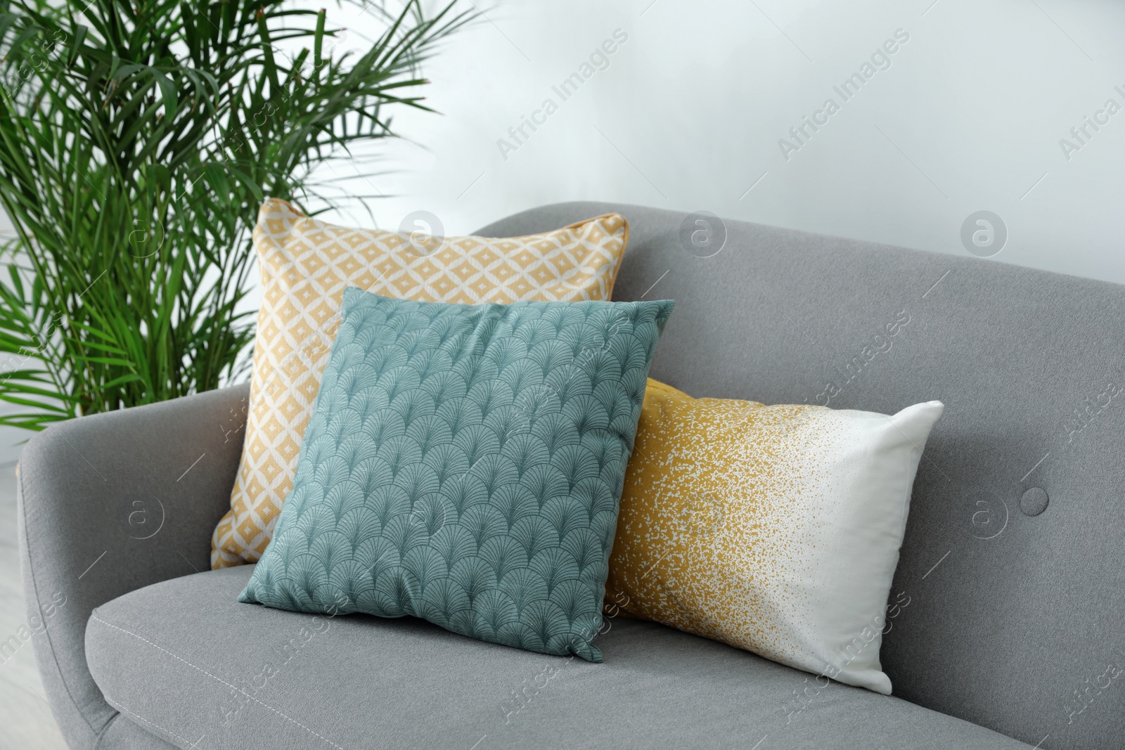 Photo of Different soft pillows on sofa in living room