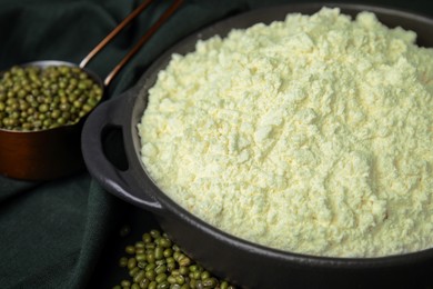 Photo of Pan with flour and mung beans on black background, closeup