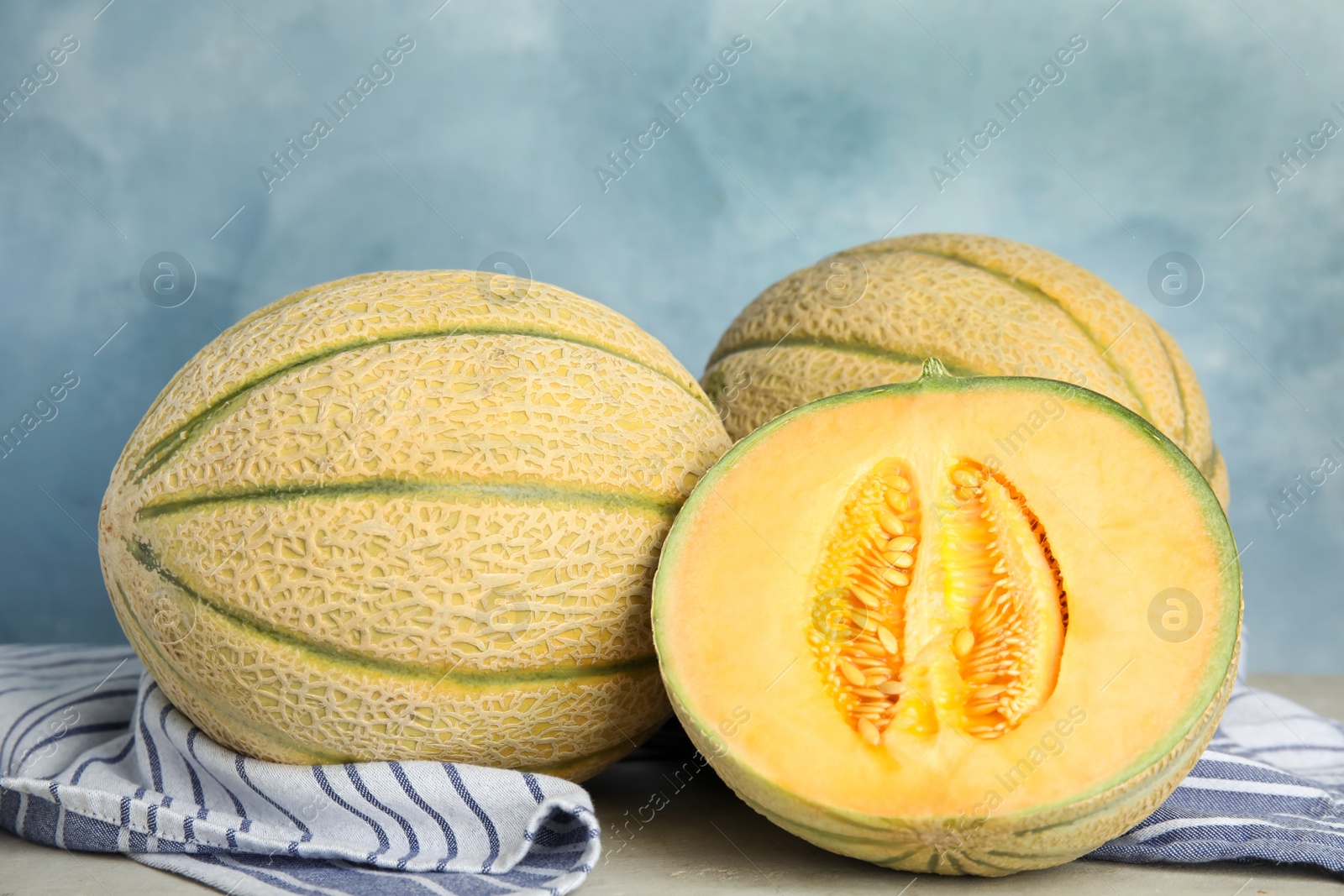 Photo of Tasty fresh melons on light grey table