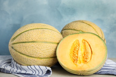 Tasty fresh melons on light grey table