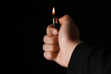 Man holding lighter on black background, closeup