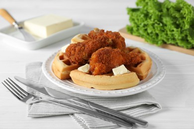 Delicious Belgium waffles served with fried chicken and butter on white table