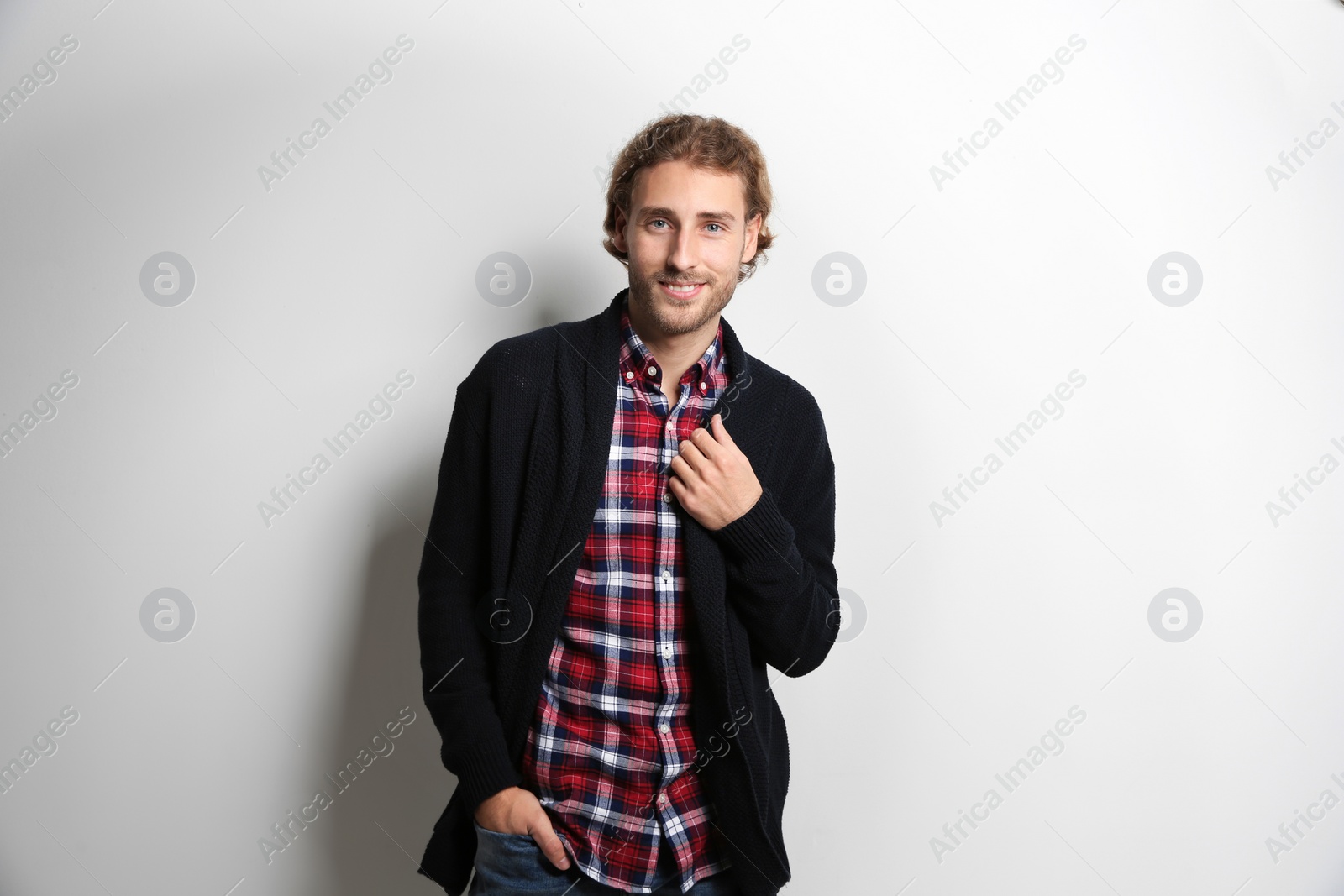 Photo of Handsome young man in shirt and warm sweater on white background