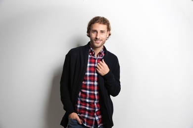 Photo of Handsome young man in shirt and warm sweater on white background