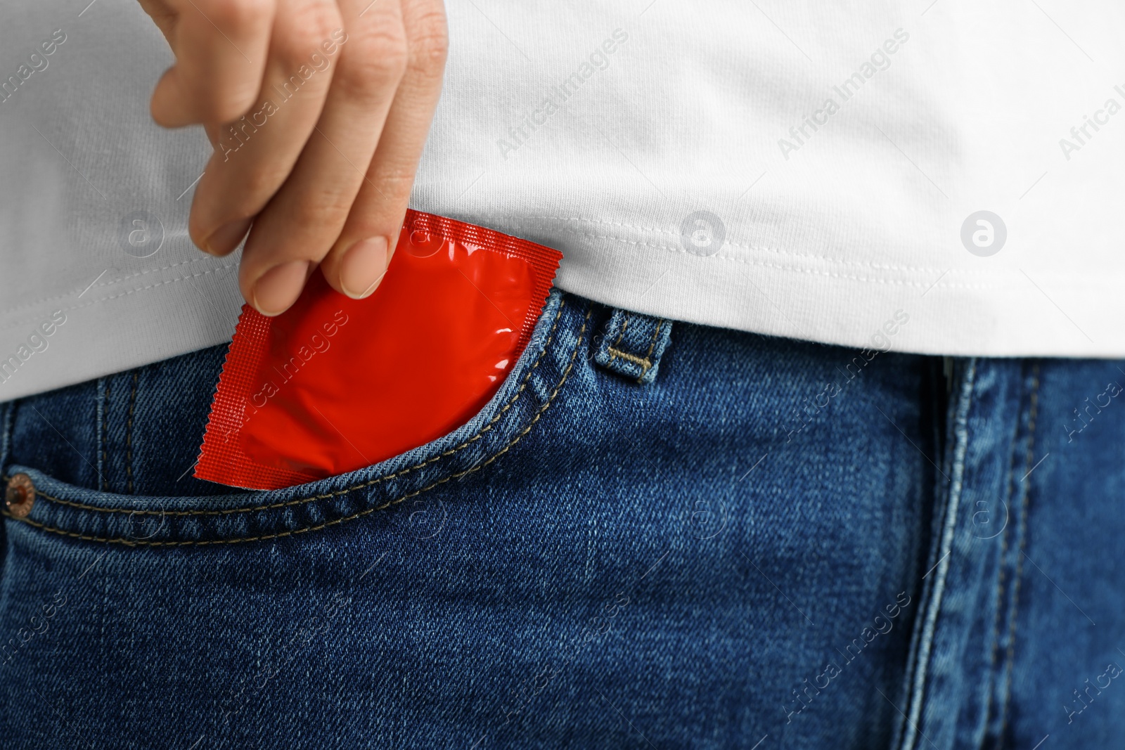 Photo of Woman pulling condom out of pocket, closeup. Safe sex