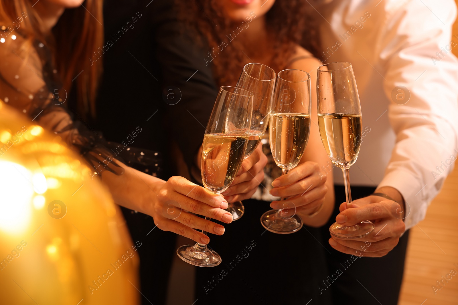 Photo of Friends with glasses of sparkling wine celebrating New Year, closeup