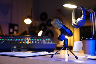 Microphone and professional mixing console on table in radio studio