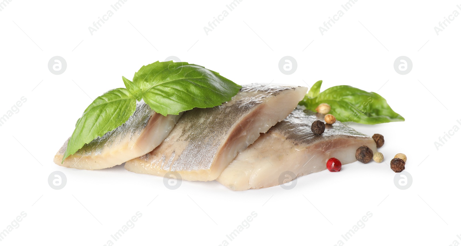 Photo of Delicious salted herring slices with basil and peppercorns on white background