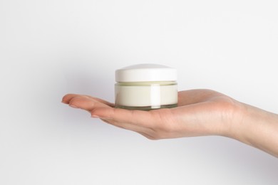 Woman with jar of cream on white background, closeup