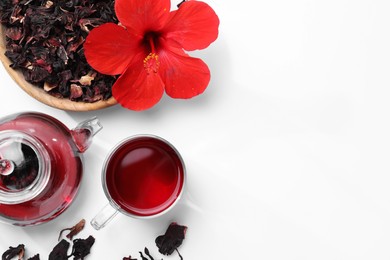 Delicious hibiscus tea and flowers on white background, flat lay. Space for text