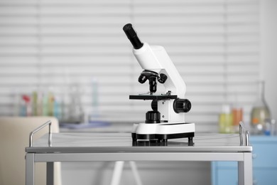 Photo of Modern medical microscope on metal table in laboratory