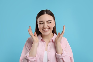 Photo of Portrait of beautiful woman laughing on light blue background