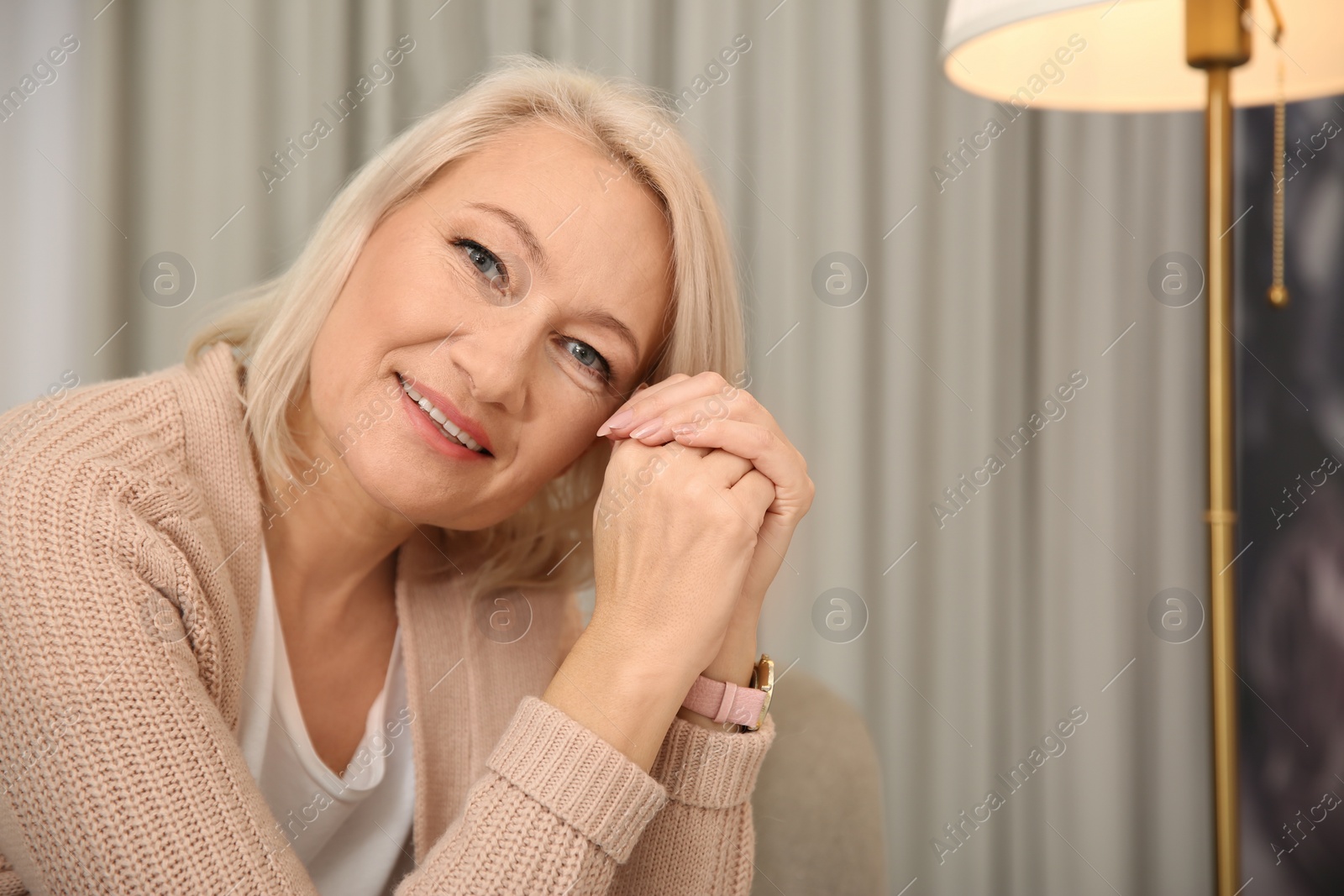 Photo of Beautiful mature woman at home. Space for text