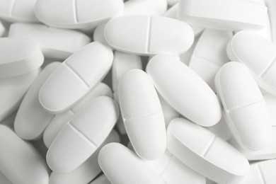 Photo of White vitamin capsules as background, top view