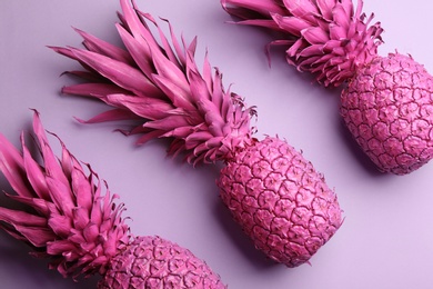Photo of Pink pineapples on light background, flat lay. Creative concept