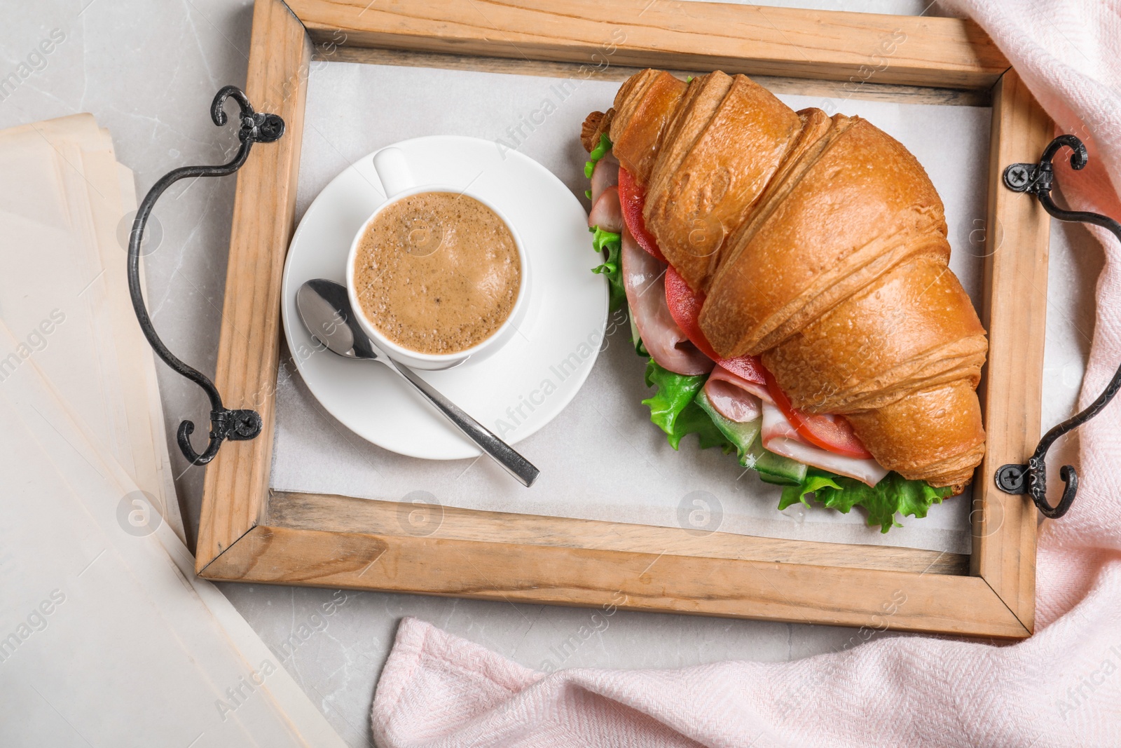 Photo of Tasty croissant sandwich and coffee on light grey marble table, flat lay