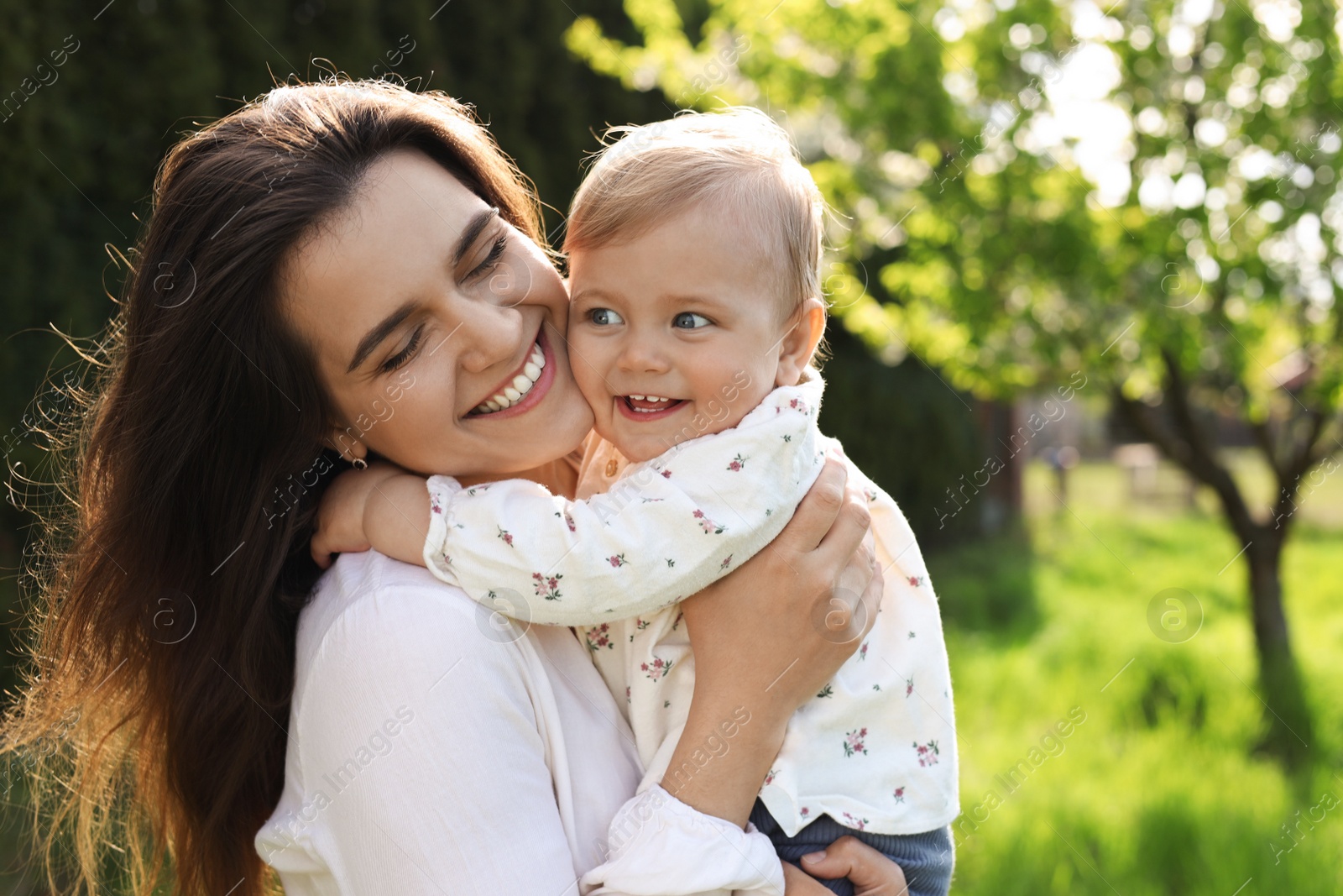 Photo of Happy mother with her cute baby in park on sunny day