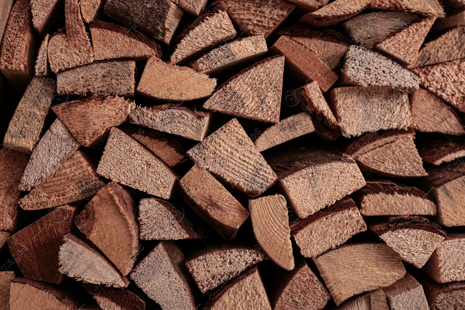 Photo of Stacked firewood as background, closeup view. Decorative material