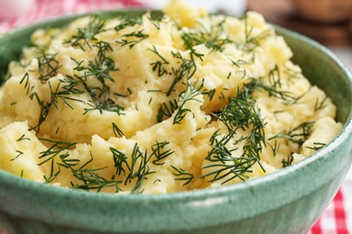 Photo of Tasty mashed potatoes served with dill in bowl, closeup