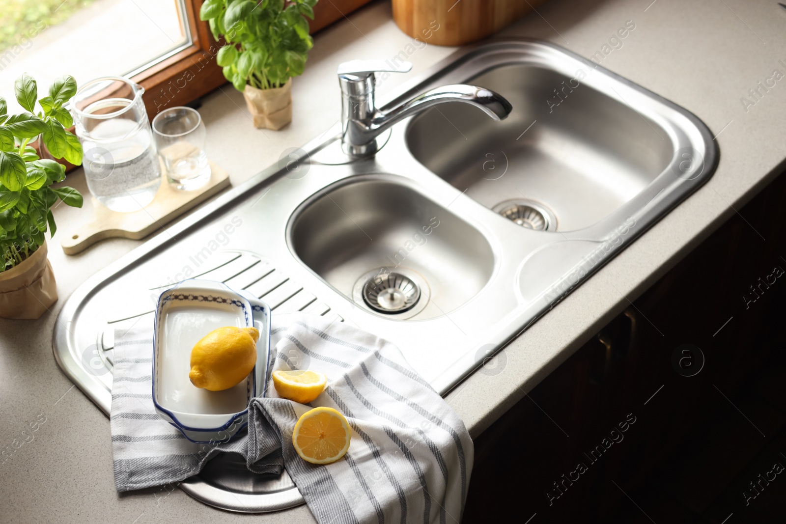 Photo of Fresh ripe lemons near sink in kitchen