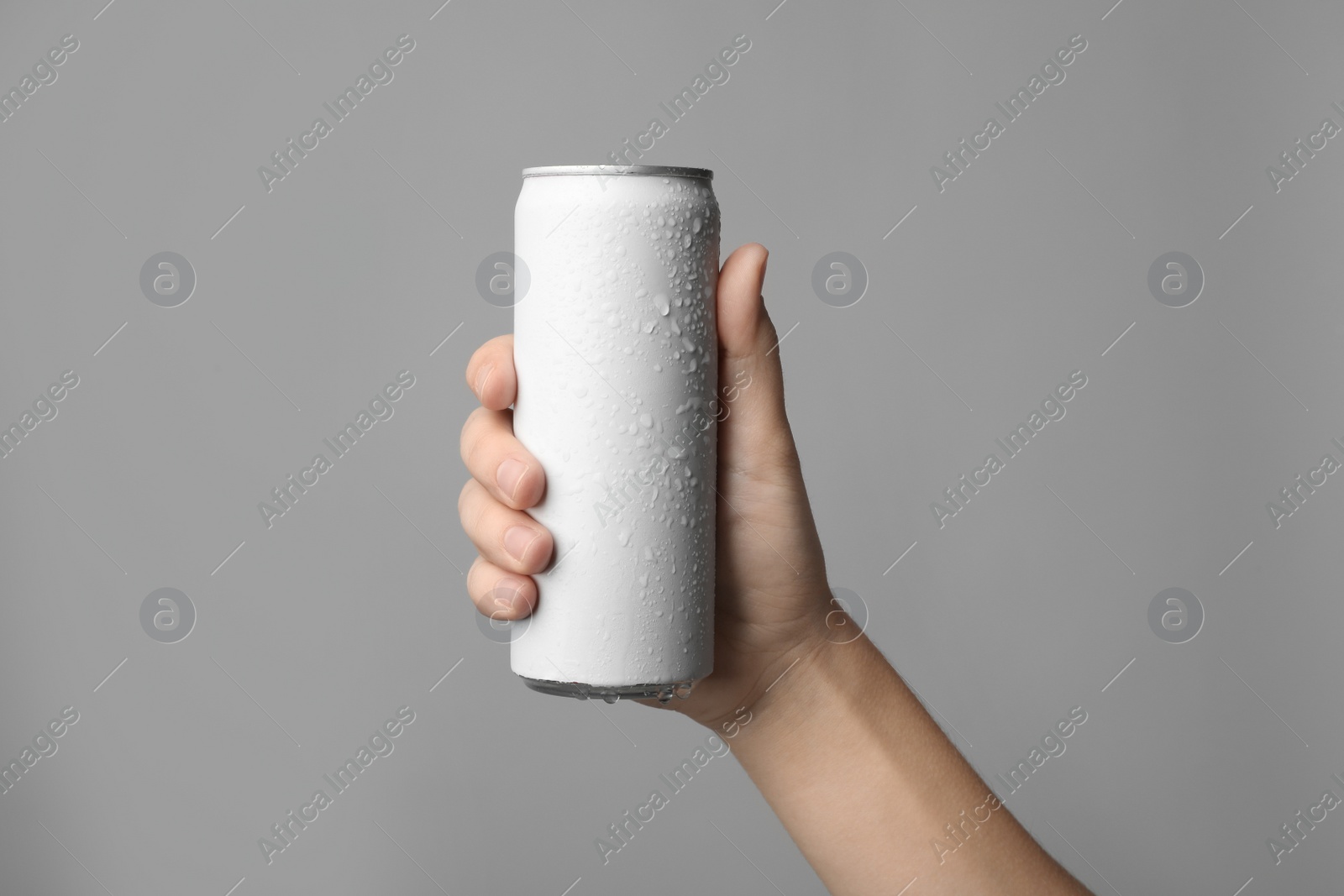 Photo of Woman holding aluminum can with beverage on grey background, closeup. Space for design