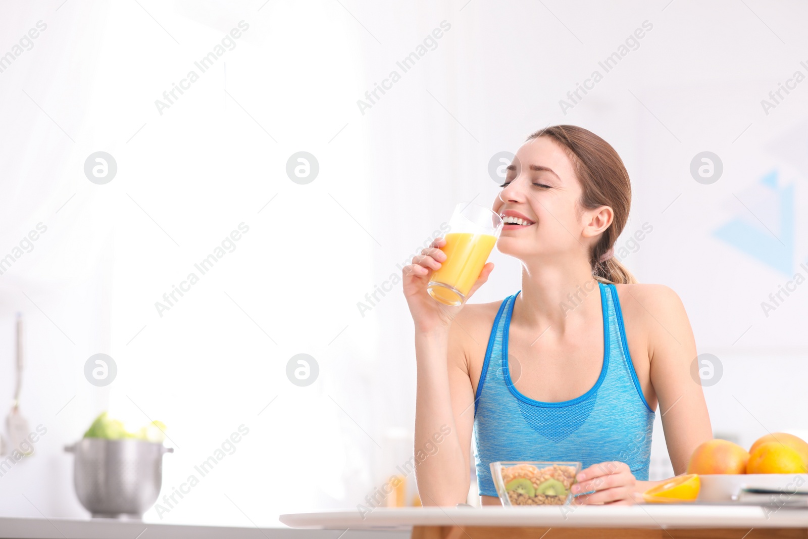 Photo of Young woman in fitness clothes having healthy breakfast at home. Space for text