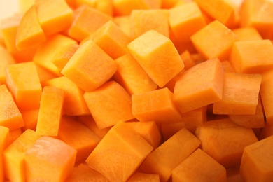 Photo of Cubes of fresh ripe carrots as background, closeup