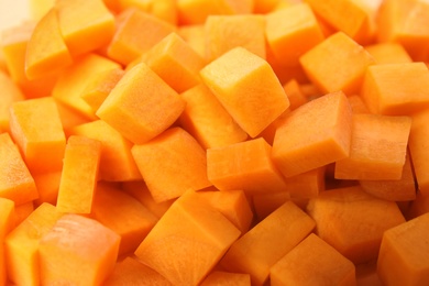 Cubes of fresh ripe carrots as background, closeup