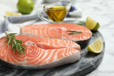 Photo of Fresh raw salmon with rosemary and lime on stone board. Fish delicacy