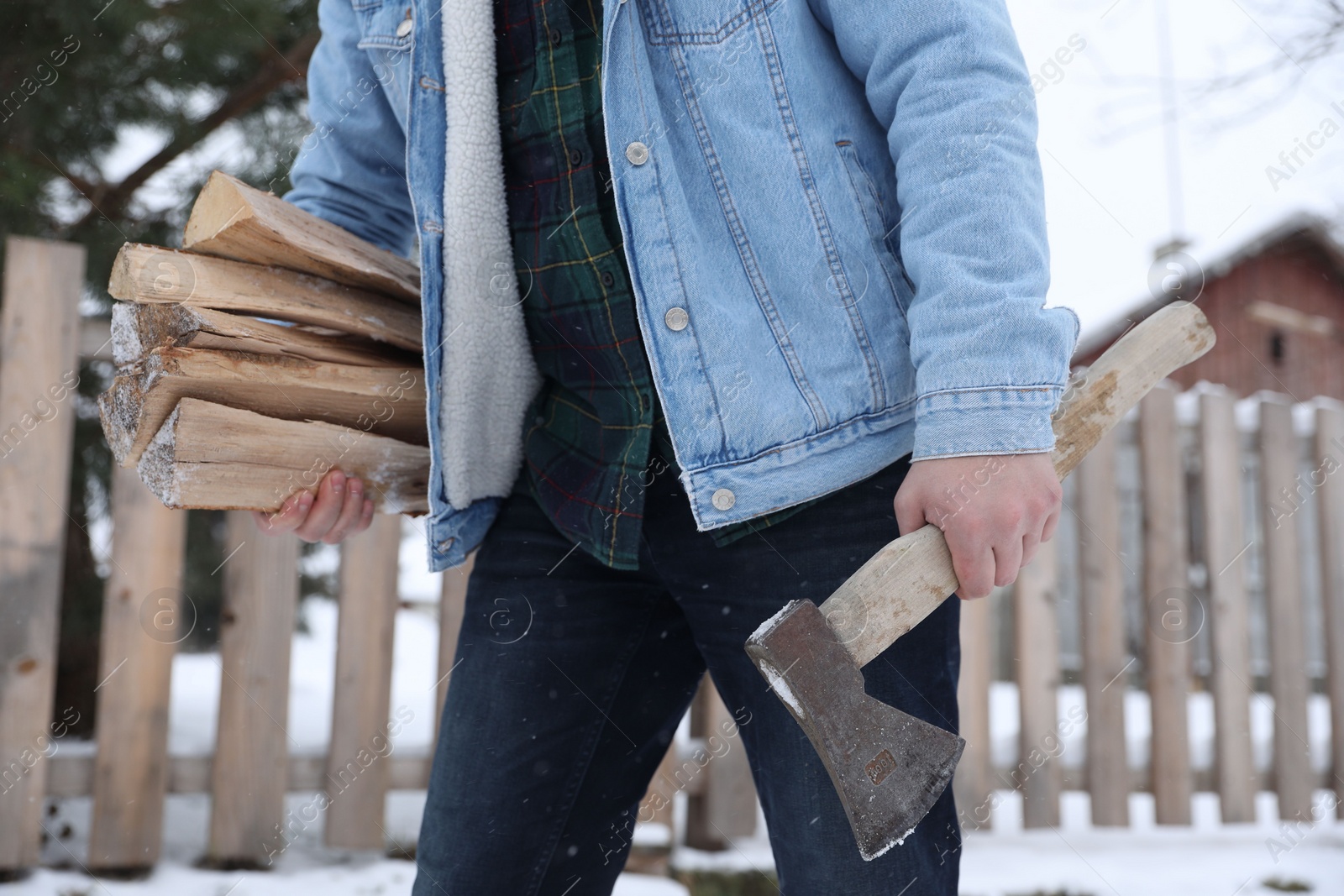 Photo of Man with axe and wood outdoors on winter day, closeup