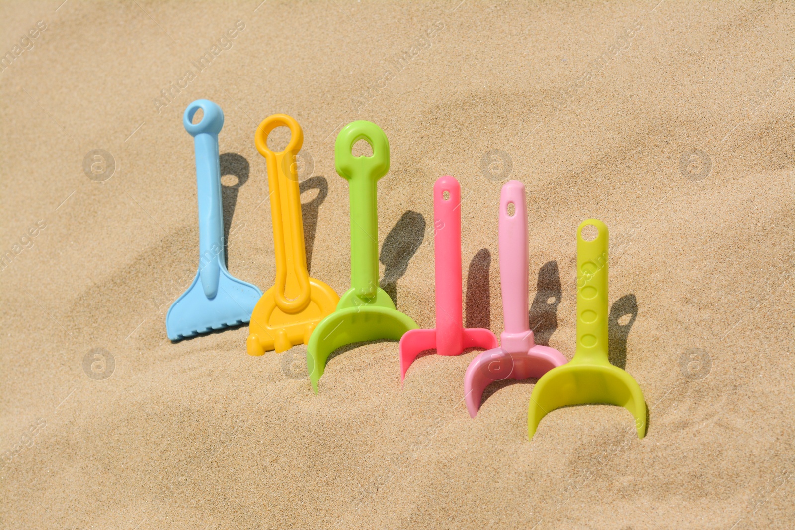 Photo of Set of colorful beach toys on sand