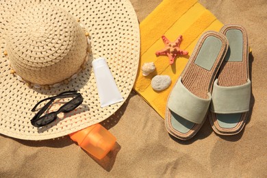 Flat lay composition with beach accessories on sand